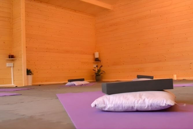 Yoga Studio Croxley Green Woman practising a gentle child’s pose stretch on a yoga mat in a wooden studio in Croxley Green.